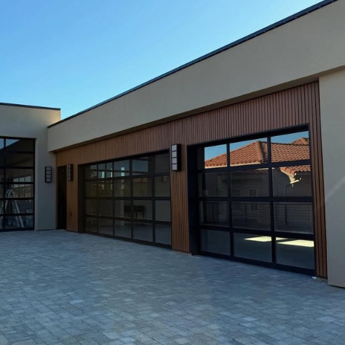 Modern 3-car garage with Amarr Full View glass garage doors, featuring black aluminum frames and full-width glass panels, installed on a contemporary home in Southern Utah.